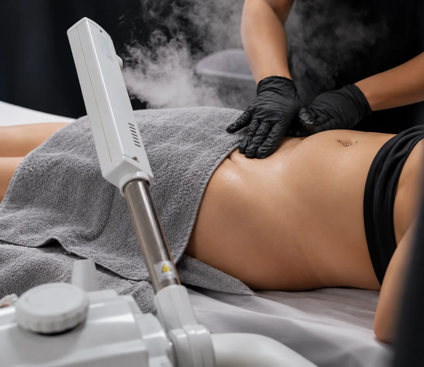Gloved hands providing skin care beside a facial steamer